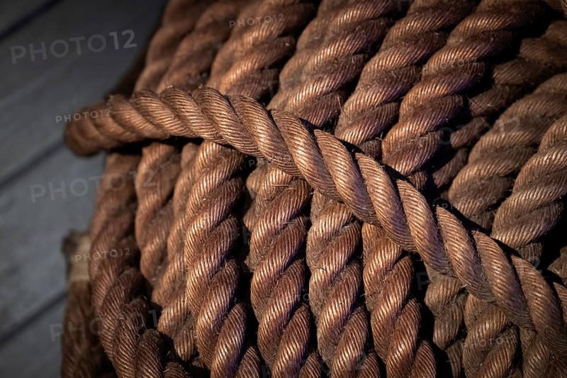 Close-up, thick rope on wooden floor, illuminated in contrast between light and shadow, Strandingsmuseum St. George, North Sea coast, Thorsminde, Denmark