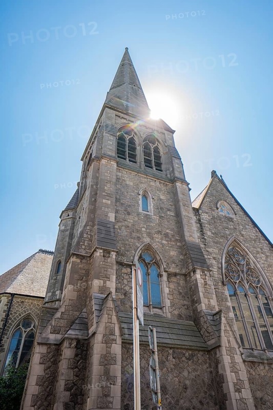 View of a church tower with Gothic architecture in sunlight, Dublin, Ireland
