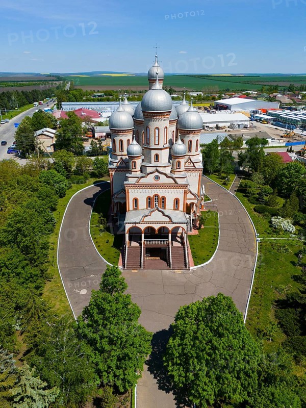Front view of an Orthodox church with several domes and entrance area surrounded by green trees, aerial view, Ascension Cathedral, Catedrala Adormirea Maicii Domnului, Drochia, Republic of Moldova, Moldova