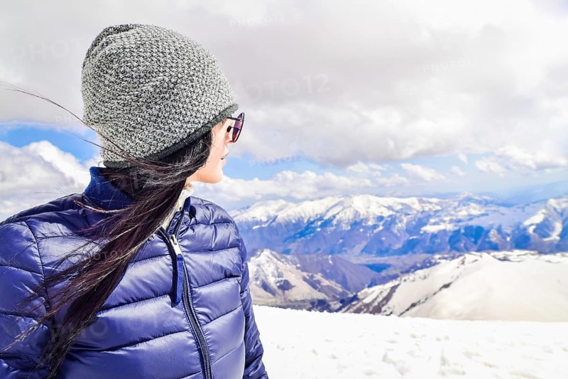 Caucasian female person enjoy winter mountains panorama in sunny ski resort. Right empty blank space copypaste winter solo holiday background.Gudauri.Georgia