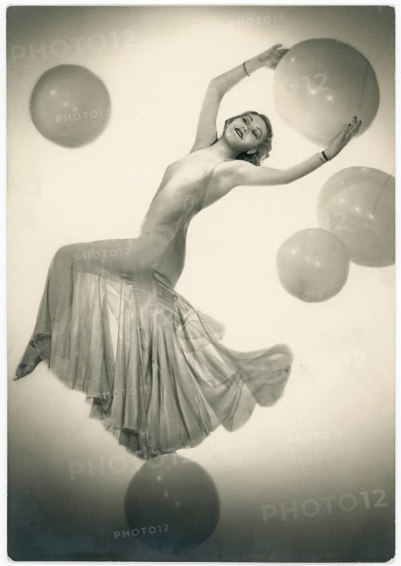 Thora Wells, dancer, Casino de Paris, cabaret, revue, elegant dancing woman in a flowing dress surrounded by floating balls, Studio Manassé, around 1929