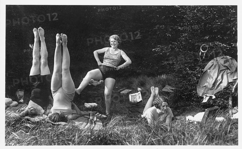 Bathing, swimwear, leisure, summer, woman doing gymnastics in a meadow while others watch in amusement, around 1930