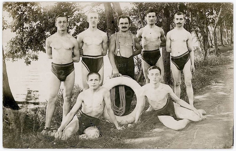 Düsseldorf, bathing, swimwear, leisure, summer, swimming club, men in swimwear posing near a river with a lifebuoy. Surrounded by trees