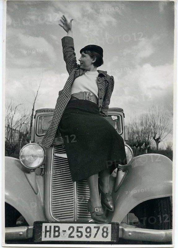 Fashion, vintage car, eagle, car, radiator figure, elegant woman, advertising photo, A woman sitting on a car and waving into the distance, Karl Theodor Gremmler, around 1935