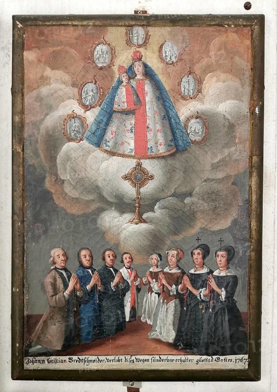 Votive image from the 18th century in the monastery church, Mönchsdeggingen monastery, former monastery of the Mariannhill missionaries, near Nördlingen on the southern edge of Riesrand, Donau-Ries district, Swabia, Bavaria, Germany. Depiction of Mary with the Infant Jesus. It is depicted in the typical Baroque type of miraculous image with a magnificent cloak, robes and crowns. The miraculous image is surrounded in a semicircle by seven small medallions, which represent the Seven Sorrows of Mary. A believing, bourgeois or rural extended family kneels in devotional prayer
