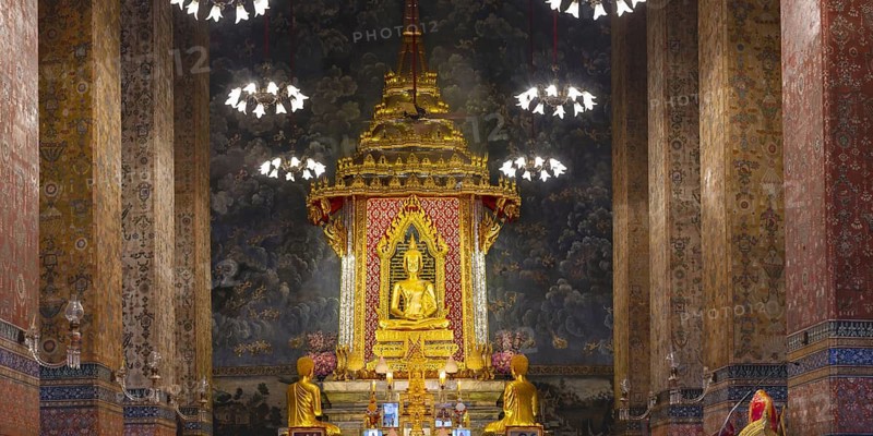 Golden meditating Buddha surrounded by wall paintings with Buddhist teachings and representations of Buddha's disciples, Wat Makut Kasatriyaram Ratchaworavihan, Phra Nakhon District, Old Bangkok, Thailand