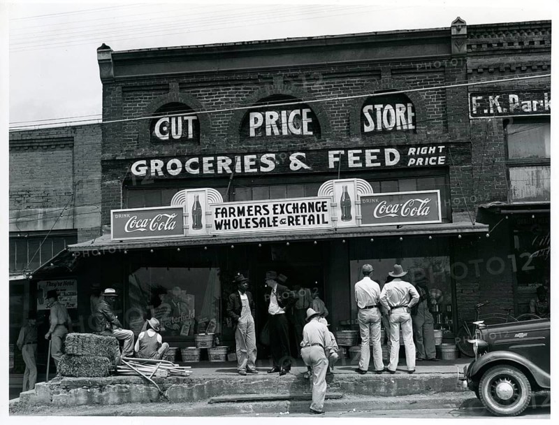 Grossmark, Farmer Shop, Farmers Exchange, Wholesale, Retail, Cut Price Store, USA, rural, An old grocery store with people in front of the building and Coca-Cola signs, caught in the rural atmosphere, around 1935