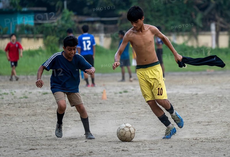 Children play football on a dusty neighbourhood field, chasing the ball with energy and determination, as the FIFA spotlight captivates fans around the world, in Guwahati, India on 27 June 2026