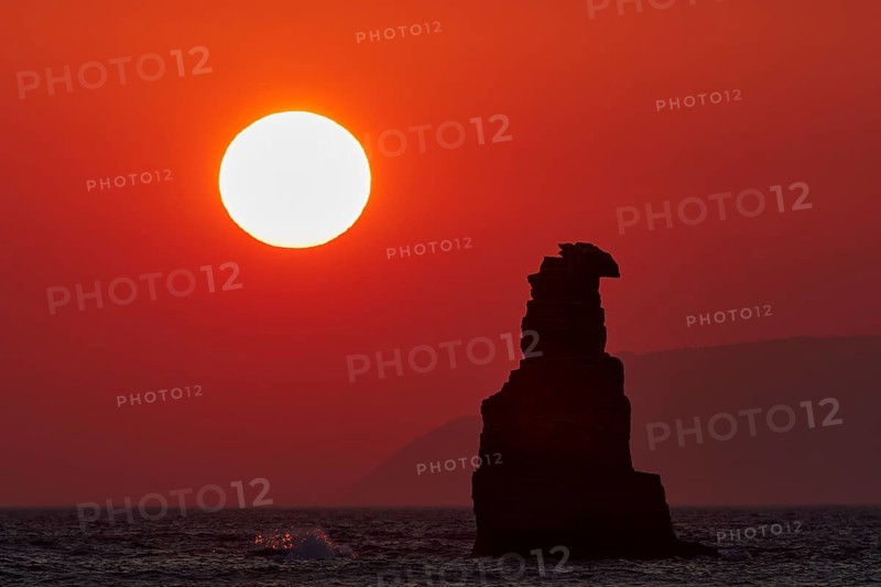 Red sunset casts an intense light on the sea and a solitary rock, sunset, South of the Amari Basin, Central Crete, Triopetra, rocks in the sea, Crete, Greek Islands, Greece