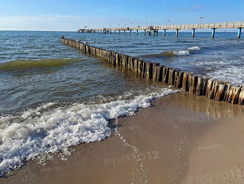 Waves hit the coast next to a jetty while the sky is clear, Graal-Müritz, Mecklenburg-Western Pomerania, Germany