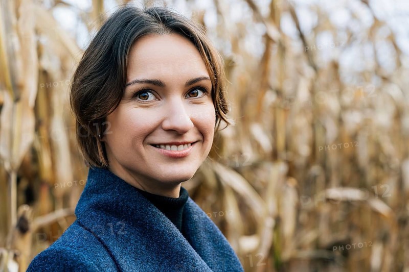 Happy smiling woman in autumn in cornfield