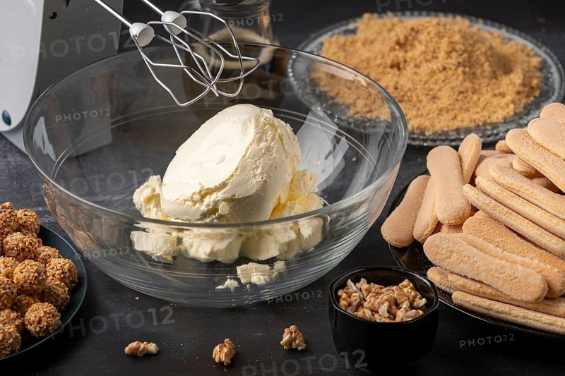 Glass bowl with quark surrounded by bisque and nuts