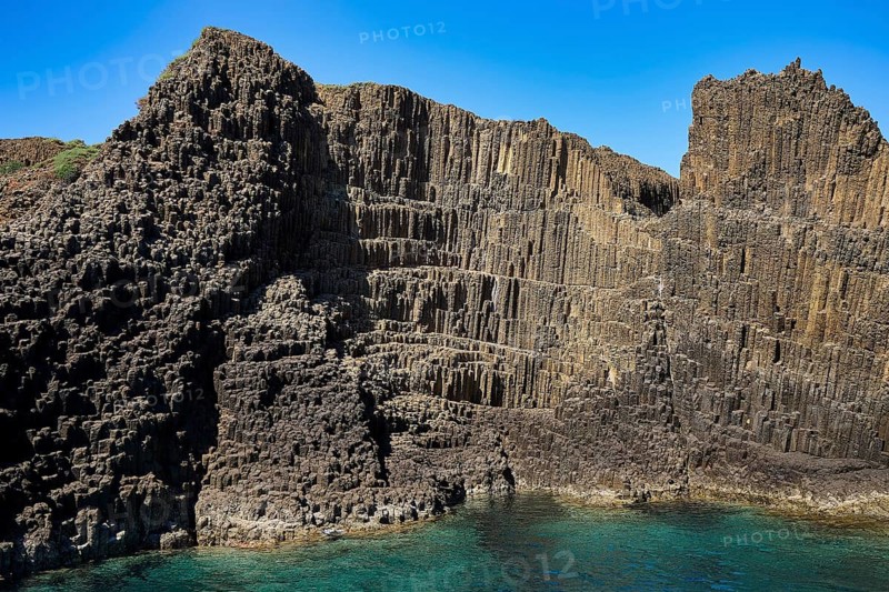 Large, impressive basalt columns rising from the rocky coastline, Glaronisia, Glaronesia, Milos, islets, hexagonal basalt columns, north of Milos, destination by boat, Cyclades, Greek Islands, Greece