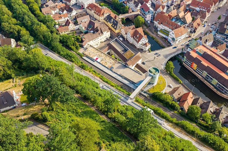 An aerial view of a city with rails and roads surrounded by green vegetation, Hermann Hesse Railway, Calw, Germany