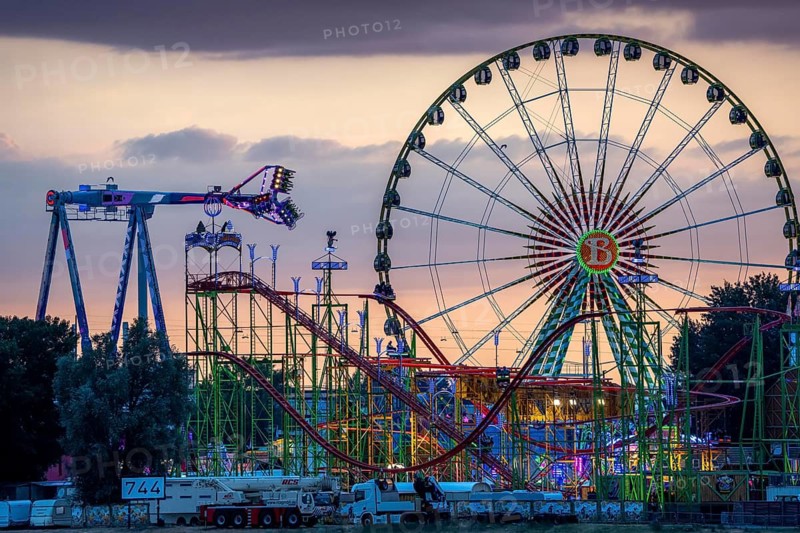 Rhine fair in the Rheinwiesen in Düsseldorf-Oberkassel, rides in the evening, with lots of lighting, Ferris wheel, infinity, world's largest mobile overhead swing, Wilde Maus rollercoaster, North Rhine-Westphalia, Germany