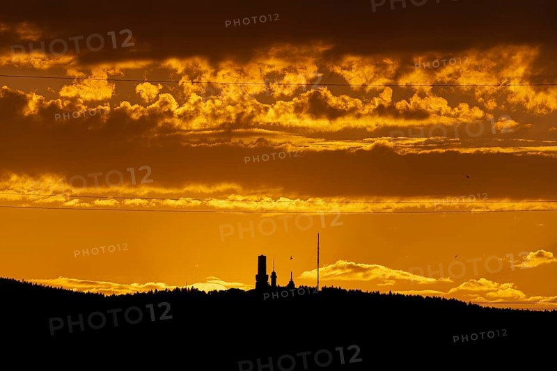 Shortly after sunset, the cloudy sky over the Großer Feldberg in the Taunus Mountains turns yellow and orange, Hesse, Germany