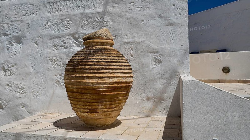 Large ceramic vessel on a roof terrace with white walls and shadows, main town on Kimolos, Kimolos, Chorio, Kimolos island, neighboring island of Milos, Cyclades, Greek Islands, Greece