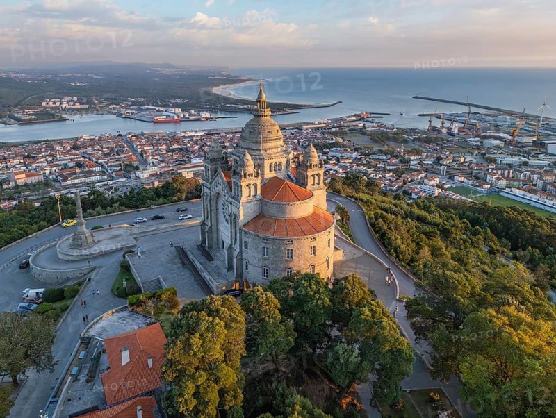 Drone shot of the Basilica of Santa Luzia at the golden hour with the city of Viana do Castelo and the Atlantic Ocean, Portugal