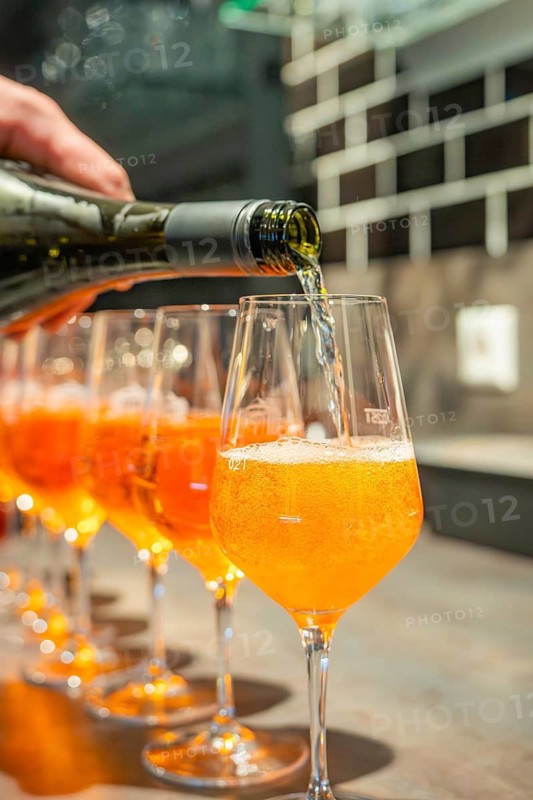 A sparkling drink is poured into aperitif glasses at a modern bar, Cafe Kuh, Deckenpfronn, Germany