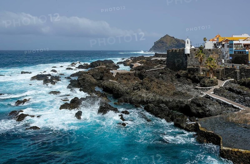 Garachico, Santa Cruz, Tenerife, Canary Islands, Spain - Garachico is a small, tranquil, picturesque town right by the sea in the northwest of the island. El Caletón public natural swimming pool, lava pools right by the sea. Swim in the open Atlantic. On the right, the tourist attraction Castillo de San Miguel