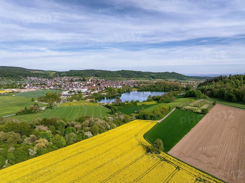 Aerial view of the municipality of Steisslingen in Hegau with Lake Steisslingen, in the foreground a blooming rapeseed field, district of Konstanz, Baden-Württemberg, Germany