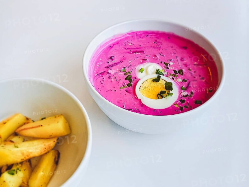 A plate with traditional Lithuanian cold summer soup of beetroot and kefir Saltibarsciai or Lithuanian kholodnik or cold borscht with baked potato wedges