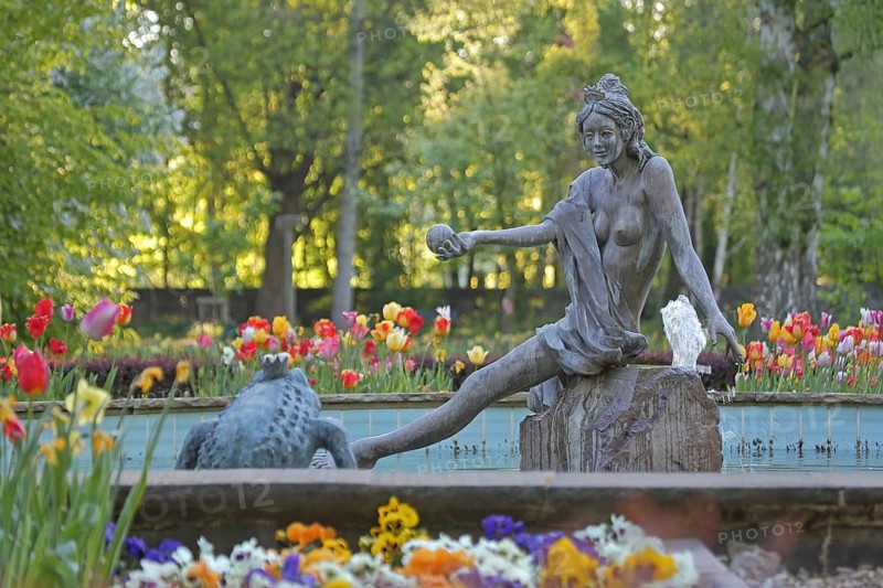 Frog Princess sculpture by Ewald Rumpf 2012, fountain with water basin, modern art, bronze sculptures, frog prince, fairy tale characters, frog figure, spring, colorful flower bed with tulips in spring, flower-bed, castle park, Rotenburg an der Fulda, Hesse, Germany