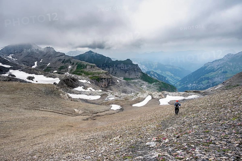 Mountaineers on hiking trail in bare rocky mountain landscape in bad weather, Rote Härd, Bernese Alps, Bernese Oberland, Switzerland
