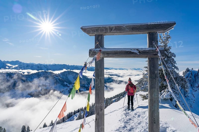 Active senior woman hiking with snowshoes on the Nagelfluh mountain chain ini the Allgaeu Alps near Oberstaufen-Steibis, Bavaria, Germany