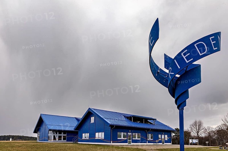 Blue building with a wavy sign against a cloudy sky, the Point Alpha memorial between Rasdorf and Geisa in the Rhön