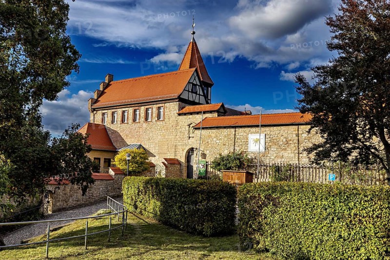 Historic building with pointed roof, lined with trees and hedges, The Lower Castle of Kranichfeld in Thuringia