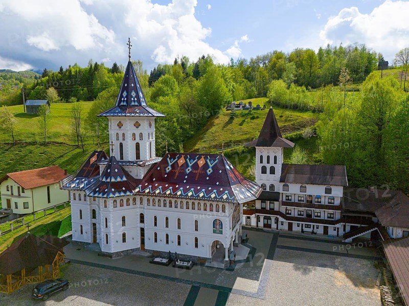 View of an Orthodox church with decorated roof surrounded by green landscape and cloudy sky, aerial view, Biserica Acoperamântul Maici Domnului, Moisei, Maramure?, Maramures, Maramuresh Region, Romania