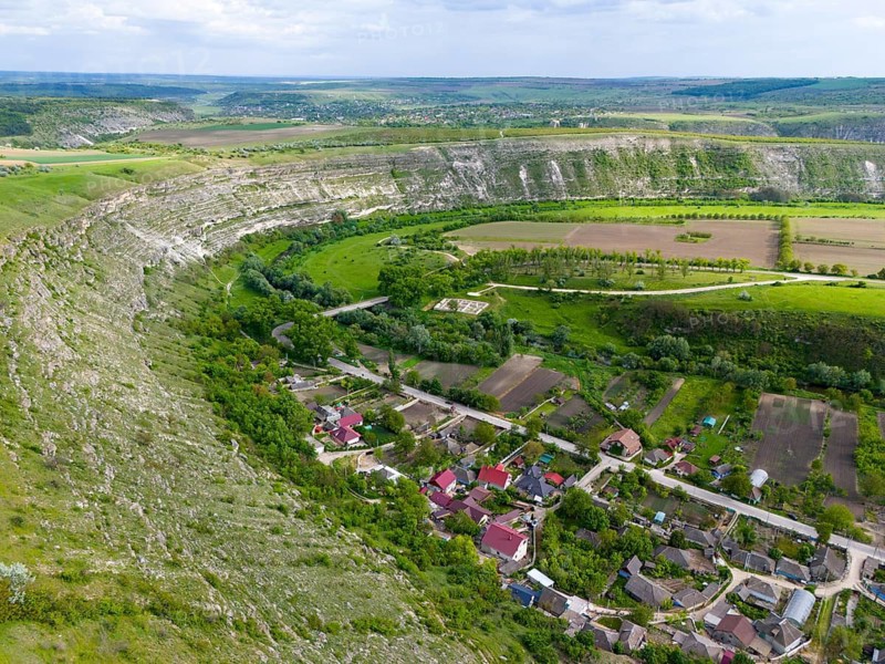 A village surrounded by hills and trees, with an adjacent river course and agricultural land, aerial view, loop of the Raut, Raut, view of Trebujeni, Old Orhei, Orheiul Vechi, archaeological site, protected landscape area, Orhei district, Republic of Moldova, Moldova
