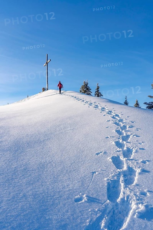 Active senior woman hiking with snowshoes on the Nagelfluh mountain chain ini the Allgaeu Alps near Oberstaufen-Steibis, Bavaria, Germany