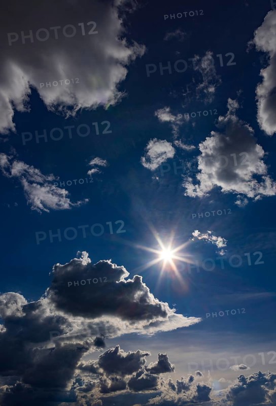 Sun shines between cumulus clouds, dramatic cloudy sky, Austria