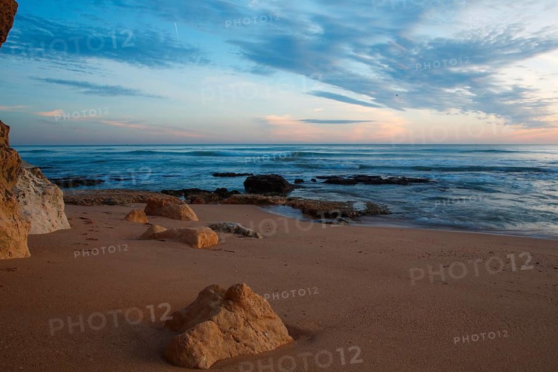 Quiet beach with rocks at sunrise, soft waves and pastel sky, sunset, Praia do Amado, Carrapateira, Algarve, West Coast, Atlantic Ocean, Portugal