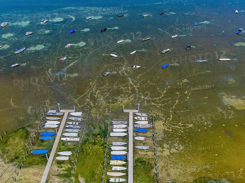 Drought on Lake Constance. The marina of Mannenbach-Salenstein in the canton of Thurgau is almost completely dry. aerial view. Boats are moored on a buoy in front of the boat docks. The lake bed is clearly visible. Mannenbach-Salenstein, Canton of Thurgau, Switzerland
