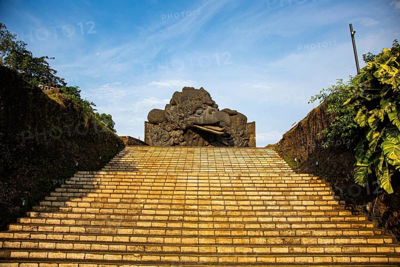 Monumental stone staircase leading up to Garuda Head under a blue sky, GWK or Garuda Wisnu Kencana Cultural Park in Bali, Indonesia