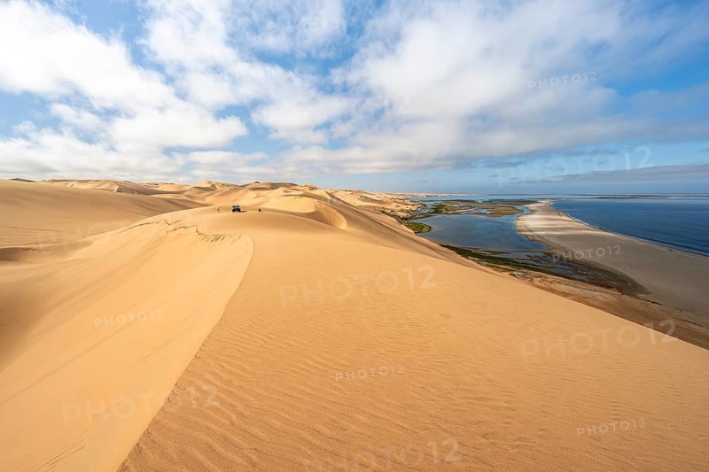 Sand dunes and sea, Atlantic coast and sandy desert with sea of dunes, view of lagoon at Sandwich Harbour, Namib Naukluft Park, Namib Desert, Namibia