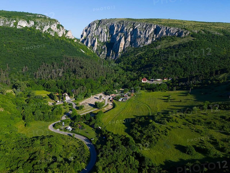 A small village nestled in a green valley flanked by impressive rock faces, aerial view, Cheile Turzii, Turda Gorge, Thorenburg Gorge, Turda, limestone gorge in the Trascau Mountains, Trascau, nature reserve, Western Carpathians, Transylvania, Romania