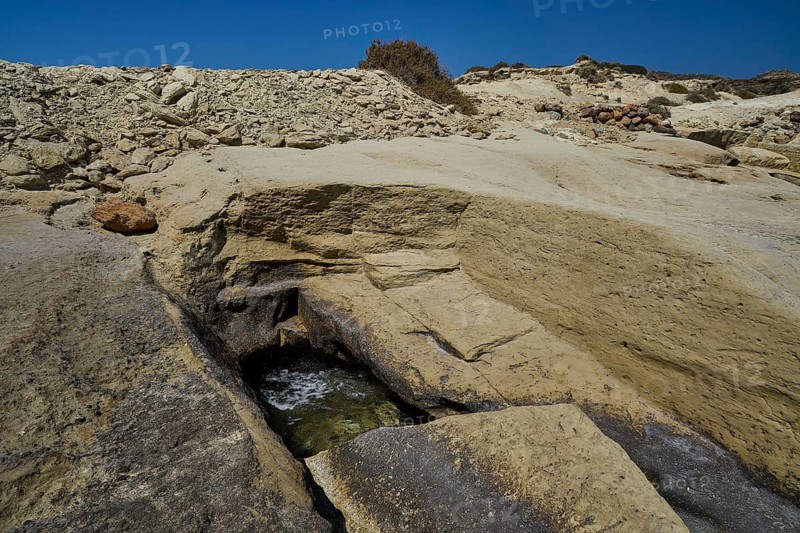 Ancient excavation remains, sandy and rocky formations on the coast in direct sunlight, Aspragremna, White Cliffs, Mavorspilia Beach, Kimolos Island, Kimolos, Cyclades, Greek Islands, Greece