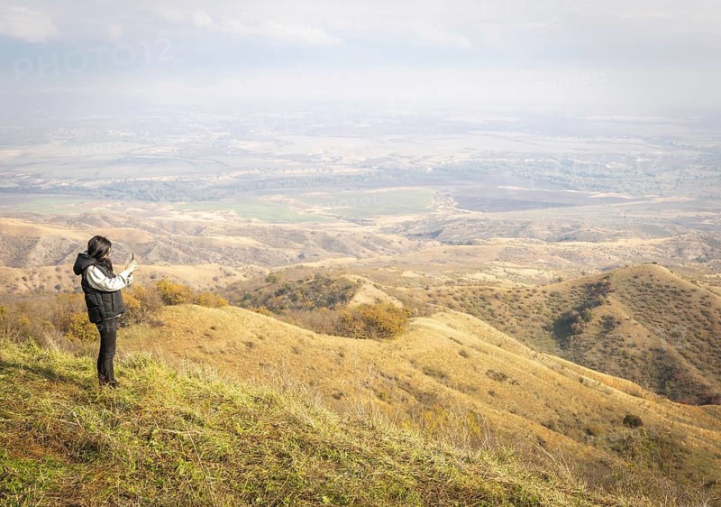 Female person takes a photo from black mountain viewpoint in Vashlovani.Georgia