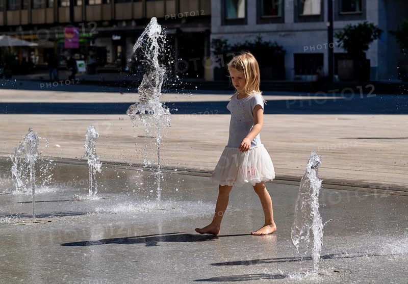 Girl, 4 years, blonde, playing barefoot with water, water playground, fountain field, market square, summer, Stuttgart, Baden-Württemberg, Germany