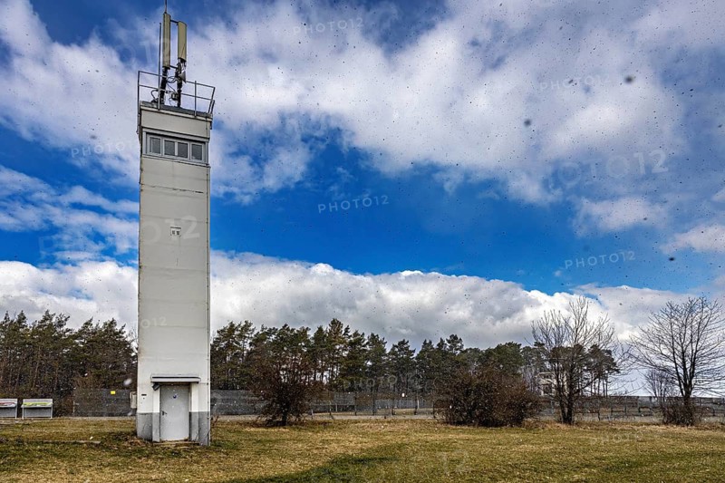 A tall watchtower rises into the blue sky, surrounded by a meadow and trees, The Point Alpha memorial between Rasdorf and Geisa in the Rhön