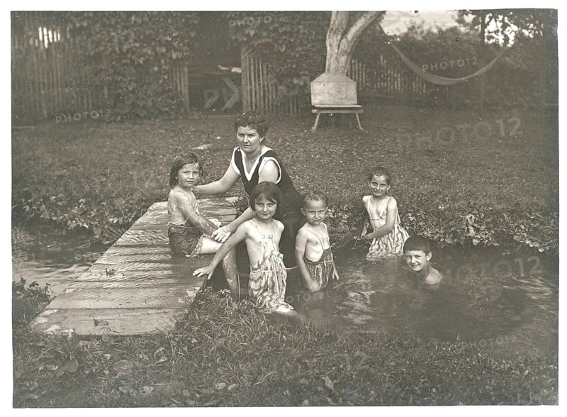 Bathing, swimwear, leisure, summer, swimming, girls, stream, children and a woman playing in a small stream in a garden, around 1924