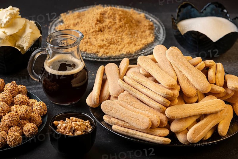 Ingredients for a dessert, such as sponge cake, nuts, sugar, and coffee
