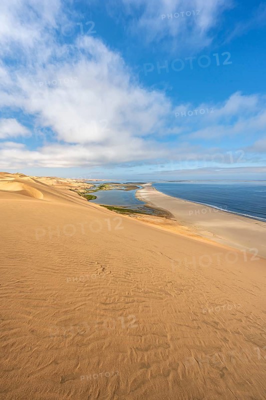 Sand dunes and sea, Atlantic coast and sandy desert with sea of dunes, view of lagoon at Sandwich Harbour, Namib Naukluft Park, Namib Desert, Namibia