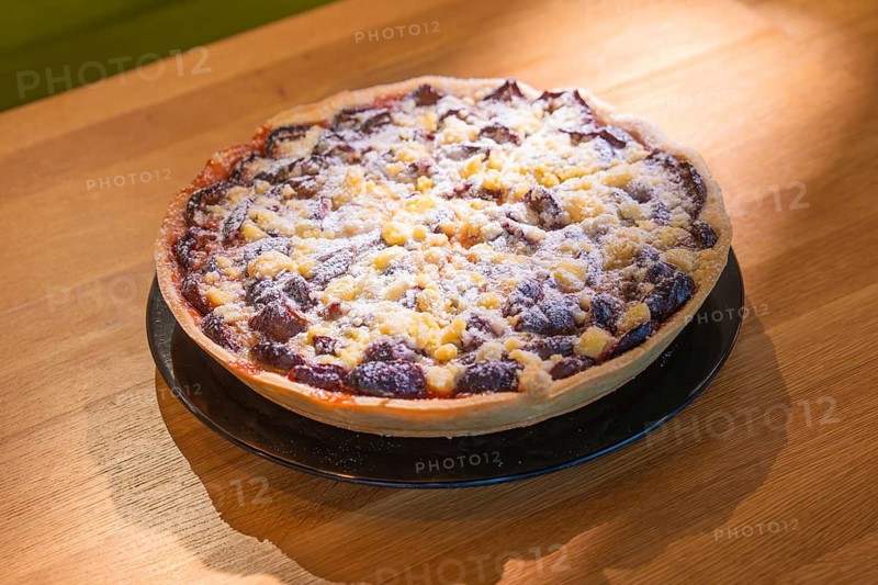 Colourful baked cake with sprinkles served on a wooden table, Café Kuh, Deckenpfronn, Germany
