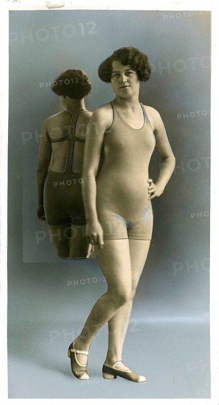 Swimwear, England, woman in swimsuit standing with reflection in the background in a studio, hand-colored, around 1926