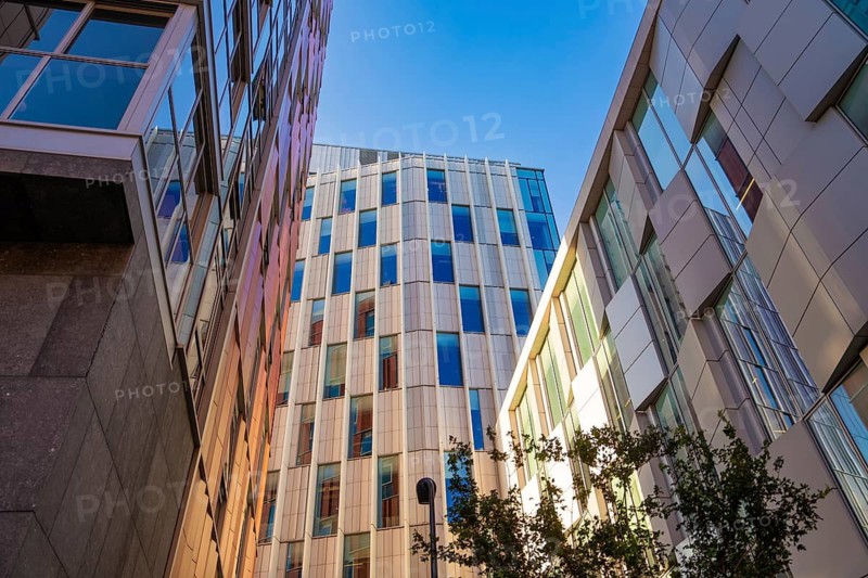 Modern glass buildings stretch out under a clear blue sky in an urban setting, Dublin, Ireland